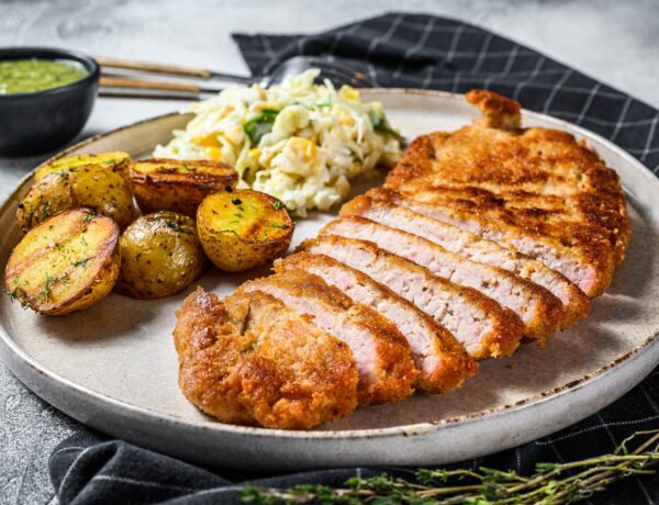 Schnitzel viennois pané avec pommes de terre au four et salade.