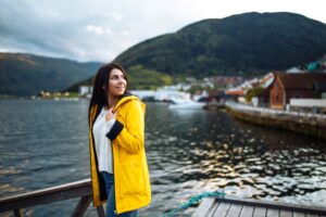 Touriste en veste jaune posant sur le lac en Norvège