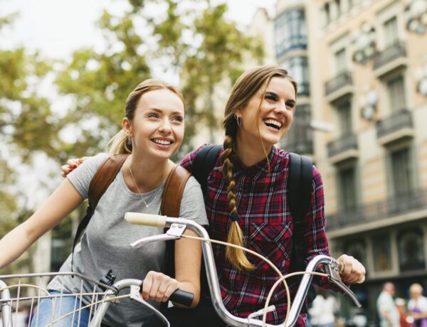 Espagne, Barcelone, deux jeunes femmes à vélo dans la ville