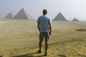 Homme vu de dos regardant les célèbres pyramides de Gizeh en Egypte, touriste, voyage