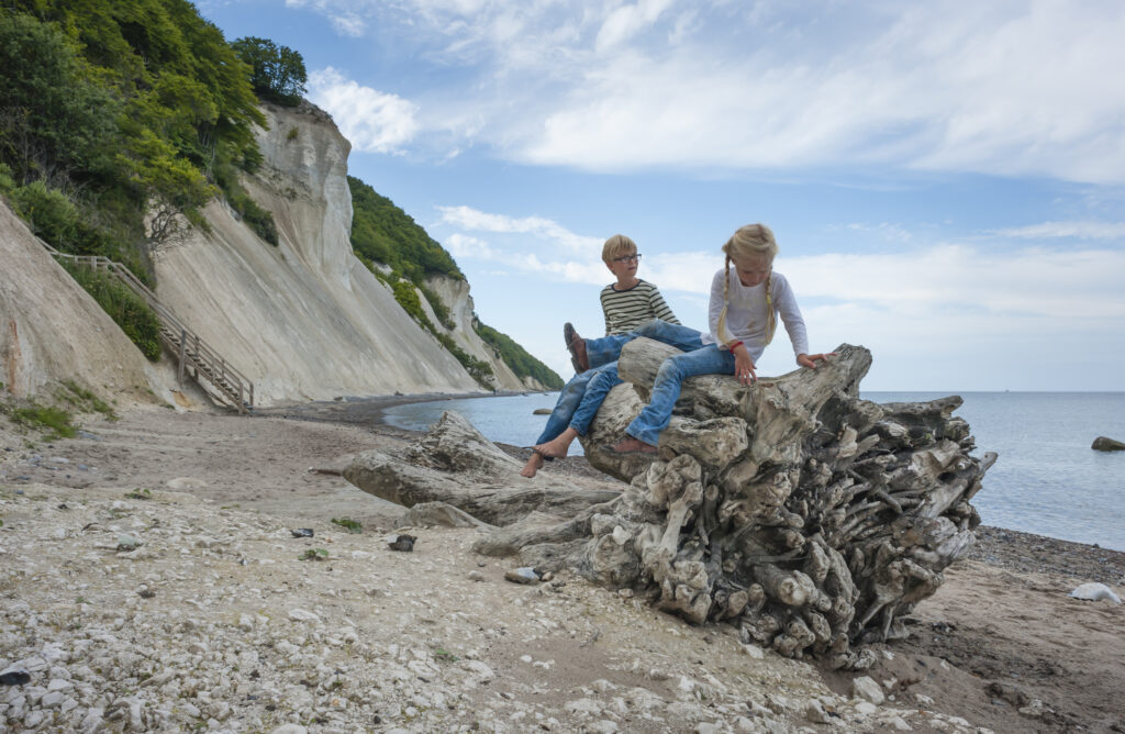 Danemark, île Mon, frères et sœurs jouant sous les falaises de craie de Mons Klint